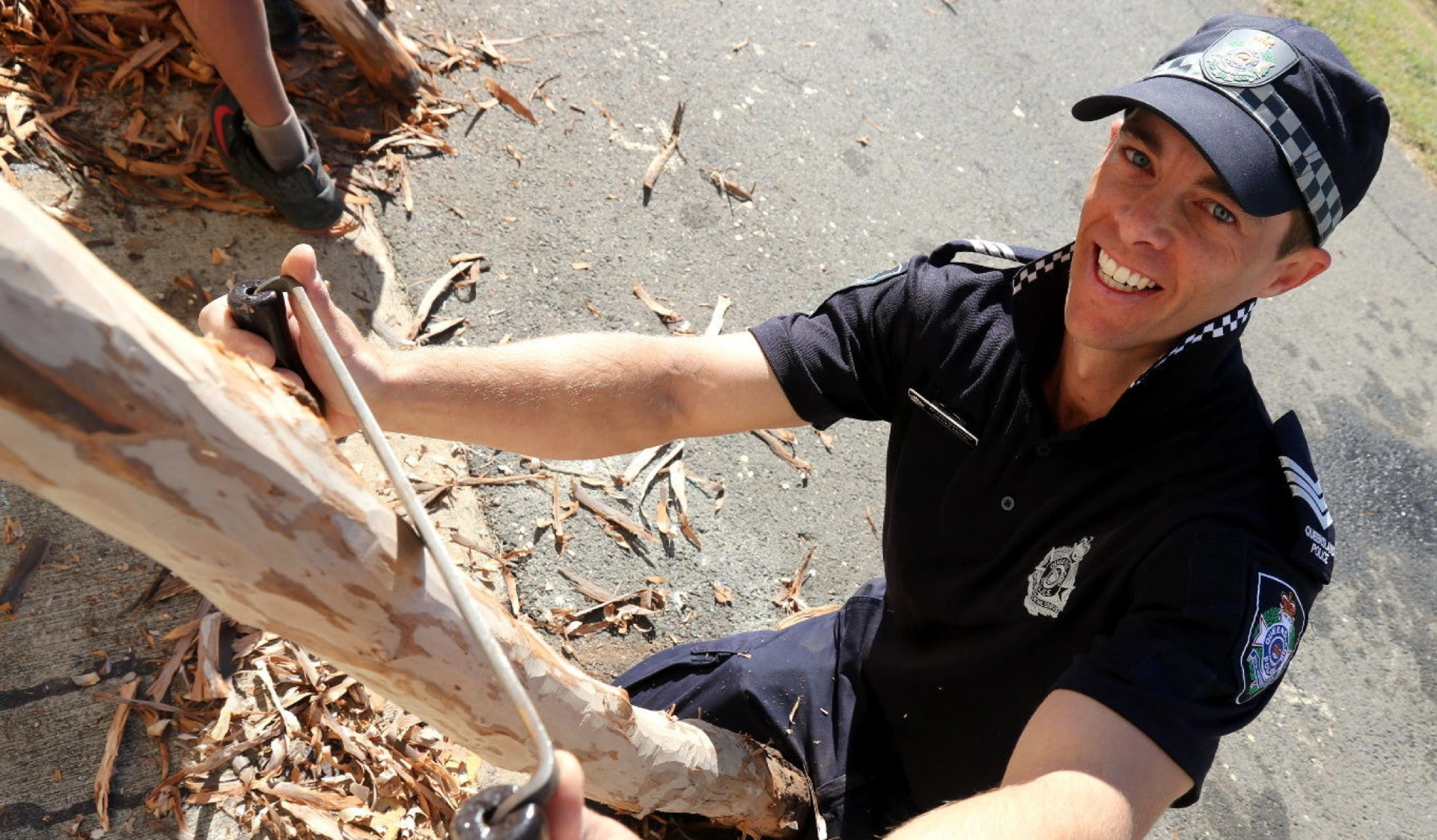 Smiling student proudly holding the didgeridoo they made during the workshop